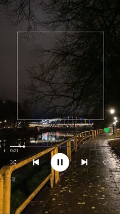 an empty square in the middle of a walkway at night with trees and lights behind it