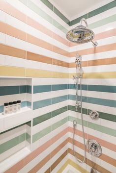 a bathroom with multicolored tiles on the wall and shower head in the corner