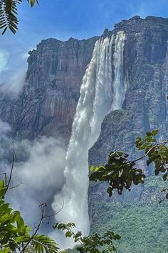 a tall waterfall towering over a lush green forest