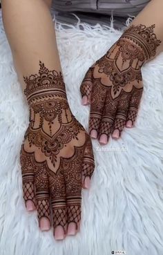 two hands with henna tattoos on them