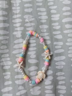 a bracelet with shells and beads on a gray background that has white circles around it