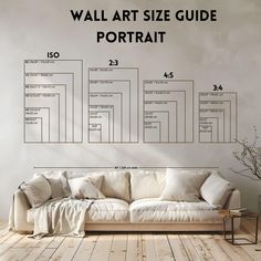 a white couch sitting in front of a wall with an art size guide on it