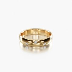 an 18k rose gold wedding ring with three diamonds on the inside and outside, set against a plain white background