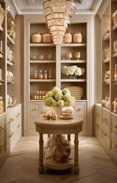 a room filled with lots of white furniture and flowers on top of a wooden table