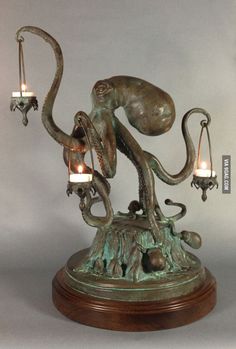 an octopus sculpture with two candles in it's tentacles