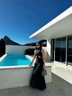 a woman standing next to a swimming pool