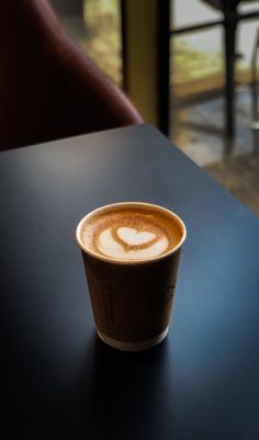 a cup of coffee sitting on top of a table