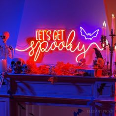 a halloween mantel with candles and decorations on it that says let's get spooky