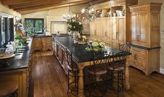 a large kitchen with wooden cabinets and black counter tops