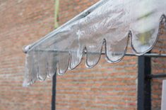 an awning on the side of a building with raindrops hanging from it