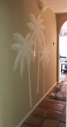 a palm tree stencil is painted on the wall in an entry way to a house