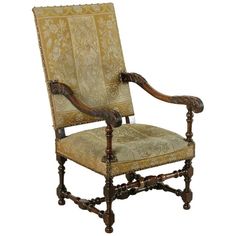 an antique chair with carved wood and upholstered fabric