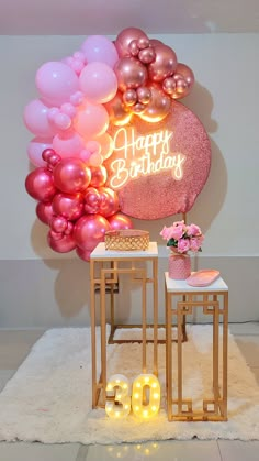 a birthday party with balloons and lights on the wall