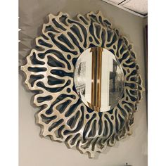 a decorative mirror hanging on the wall above a sink in a room with white walls