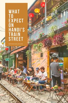 people sitting at tables on the side of train tracks with text overlay that reads what to expect on hanjo's train street