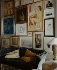 a living room filled with furniture and pictures on the wall