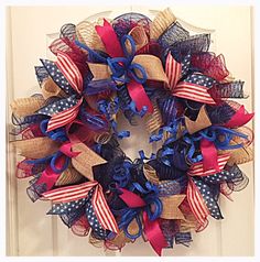 a patriotic wreath with red, white and blue ribbons