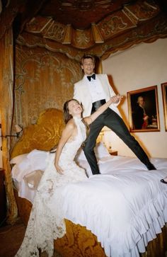 a man and woman are posing on a bed