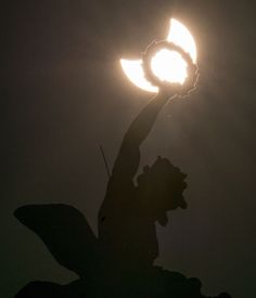 the silhouette of a person holding a circular object in their hand