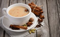 a cup of coffee with cinnamon and star anise on the side