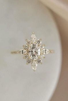 a white plate with a ring on it that has an oval diamond in the center