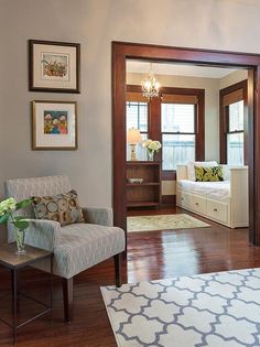 a living room filled with furniture and pictures hanging on the wall above a door that leads to a bedroom