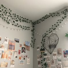 a room with many pictures on the wall and string lights strung from the ceiling above it