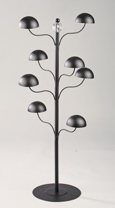 a metal tree with five lights on each side and a round base in the middle