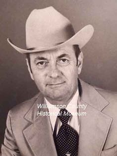 black and white photograph of a man in a suit with a hat on his head