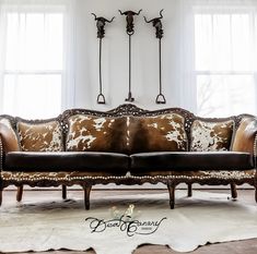 a couch sitting in the middle of a living room next to two lamps and windows