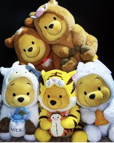 several winnie the pooh stuffed animals sitting next to each other