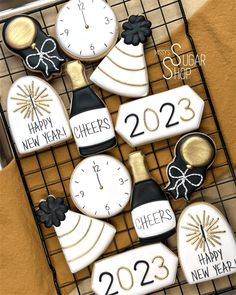 cookies decorated with new year's decorations on a cooling rack for someone to decorate