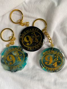 three glass key chains with gold numbers on them