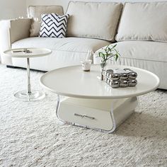 a living room filled with furniture and a white table on top of a carpeted floor