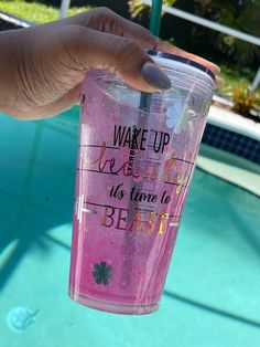 a hand holding a pink tumbler with the words wake up and it's time to beat