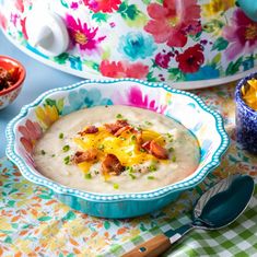 there is a bowl of soup on the table with other bowls and utensils