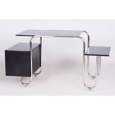 two tables sitting next to each other on metal legs and one has a black box underneath it