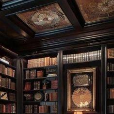 the room has many bookshelves with decorative paintings on them and two lamps at the end