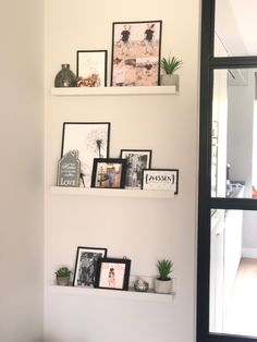 three white shelves with pictures and photos on them