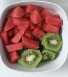 sliced kiwis in a white bowl on a table