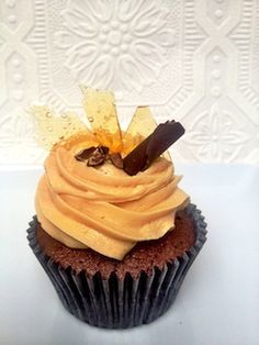 a chocolate cupcake with frosting and chips on top