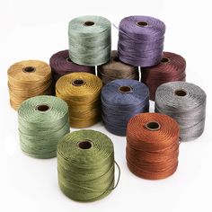 several spools of twine are shown in different colors and sizes on a white background