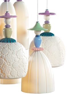 three white and green glass lamps hanging from the ceiling in front of a white background