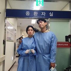 a man and woman in scrubs standing next to each other near an airport entrance