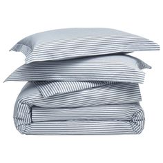 three pillows stacked on top of each other with blue and white striped sheets in the background