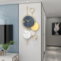 a clock on the wall next to a table with a potted plant in front of it