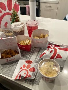 several boxes of food sitting on top of a table next to cups and napkins