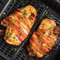 two pieces of chicken sitting on top of a grill