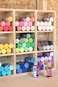 the shelves are filled with different colors of paint and some other crafting supplies on them