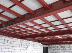 an unfinished room with red beams and white bricks